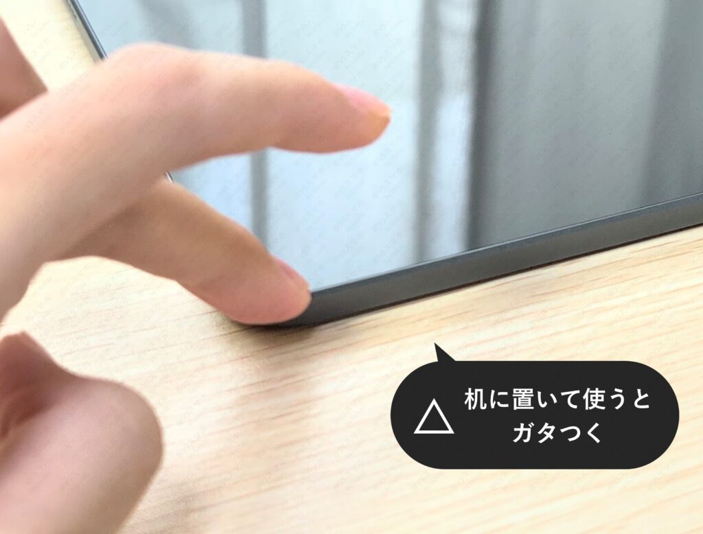 Xiaomi Pad 6S Pro 12.4を机に置いて端を指で押している写真。カメラの出っ張りによりガタつき（揺れ）が発生することを示す検証結果